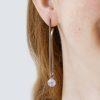 long drop earrings in 18ct white gold with detachable round prehnite bead drops. shown on model's ear.