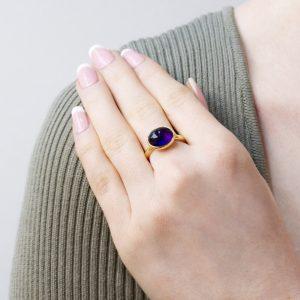 oval amethyst cabochon (4.46ct) in 18ct yellow gold shown on model hand