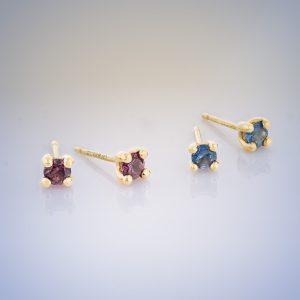 two pairs of 18ct yellow gold stud earrings with claw-set gemstones - red ruby and blue sapphire